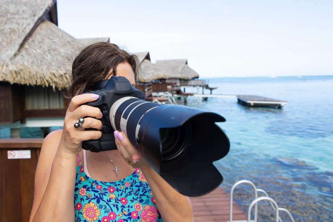 Female photographer taking a photo with long lens DSLR